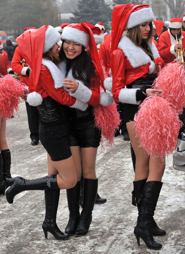 Девушки в костюмах Санта-Клауса во время новогоднего парада в Бишкеке  - Sputnik Lietuva