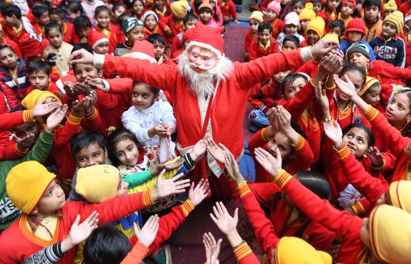 Девушка в костюме Санта-Клауса раздает подарки детям в Индии  - Sputnik Lietuva