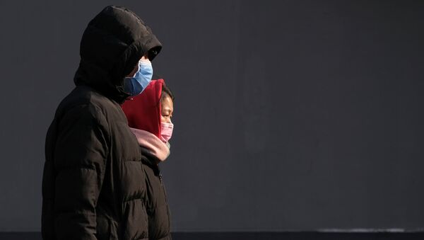 Люди в защитных масках идут по улице в Пекине, 24 января 2020 года - Sputnik Литва