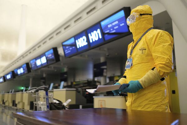 Работник в защитном костюме в аэропорту Уханя - Sputnik Lietuva