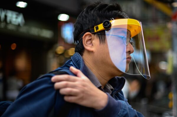 На фото: мужчина носит защитную маску на улице. Снимок сделан в Гонконге. - Sputnik Литва