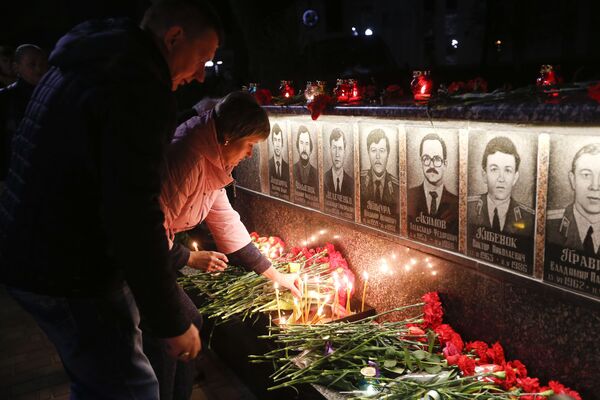 Люди возлагают цветы и зажигают свечи во время проведения акции памяти ликвидаторов и жертв аварии на Чернобыльской атомной электростанции в городе Славутич - Sputnik Lietuva