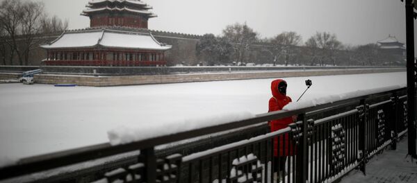 Девушка в маске во время селфи у Запретного города в Пекине  - Sputnik Литва