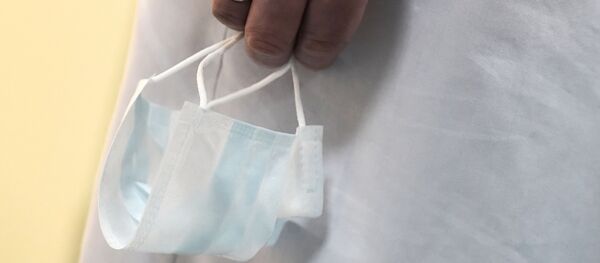 Медицинская маска в руке медика, архивное фото - Sputnik Литва