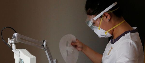 Косметолог в защитной маске и очках снимает маску для лица во время процедуры в спа-салоне красоты Pearl Deluxe в Пекине, 5 марта 2020 года - Sputnik Lietuva