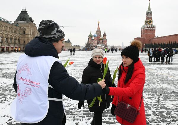 Волонтер дарит цветы и поздравляет женщин с Международным женским днем на Красной площади - Sputnik Lietuva