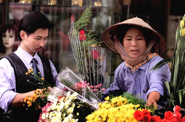 Молодой вьетнамец покупает розы в старом квартале Ханоя, Вьетнам - Sputnik Lietuva
