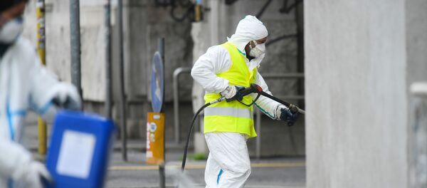 Рабочий убирает улицы в Милане, 13 марта 2020 года - Sputnik Литва