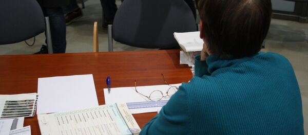 Сотрудник избирательной комиссии в ожидании избирателя Сотрудник избирательной комиссии в ожидании избирателя - Sputnik Литва