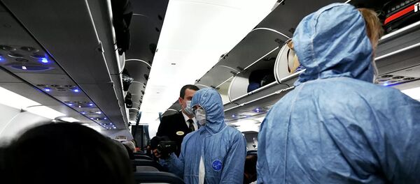 Сотрудники Роспотребнадзора измеряют температуру пассажиров на борту самолета в аэропорту Шереметьево Сотрудники Роспотребнадзора измеряют температуру пассажиров на борту самолета в аэропорту Шереметьево - Sputnik Lietuva