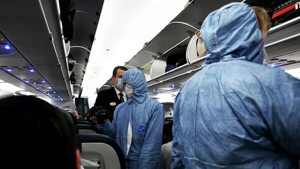 Сотрудники Роспотребнадзора измеряют температуру пассажиров на борту самолета в аэропорту Шереметьево - Sputnik Lietuva