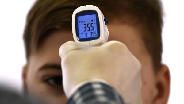 Медицинский работник измеряет температуру школьнику в одной из школ Москвы - Sputnik Lietuva