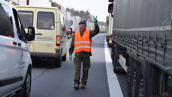 Солдаты вооруженных сил Германии доставляют продовольствие водителям грузовиков, попавшим в пробку на шоссе А 4 близ Гёрлица - Sputnik Литва