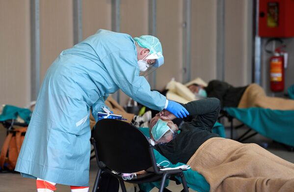 Врач помогает пациенту во временной больнице в Брешиа, Италия - Sputnik Lietuva