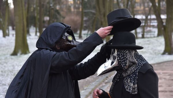 Прохожие в карнавальных масках на одной из улиц во Львове - Sputnik Литва