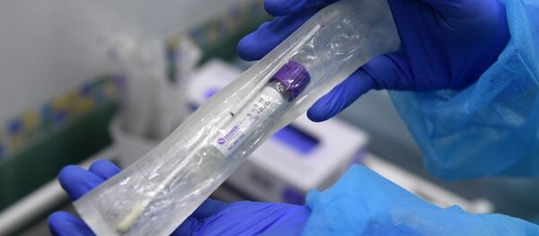 Пробирка с тестом на коронавирус в руках у сотрудницы в медицинской лаборатории - Sputnik Литва