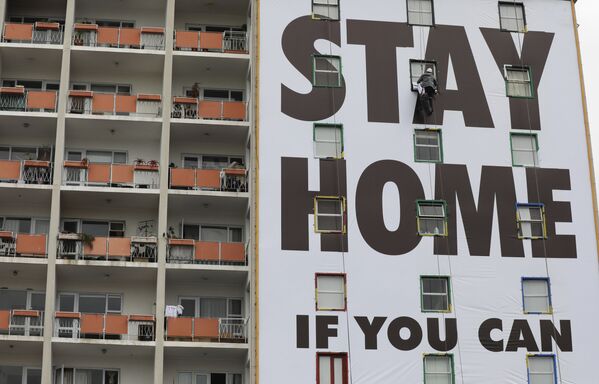 Рекламный плакат с призывом остаться дома на здании в Южной Африке  - Sputnik Lietuva