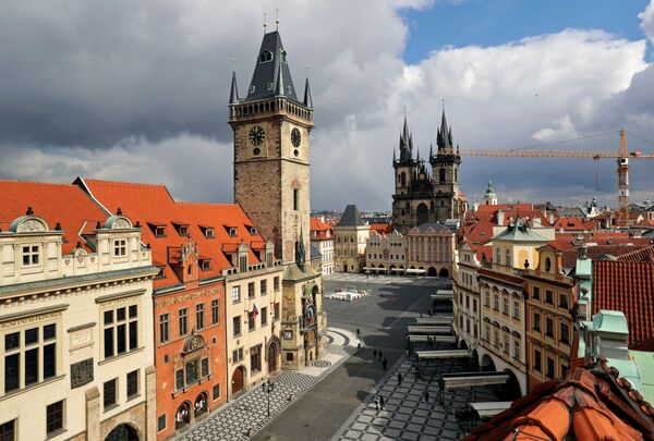 Показывающие полдень часы на ратуше на фоне пустой Староместской площади в Праге в период пандемии коронавируса - Sputnik Литва