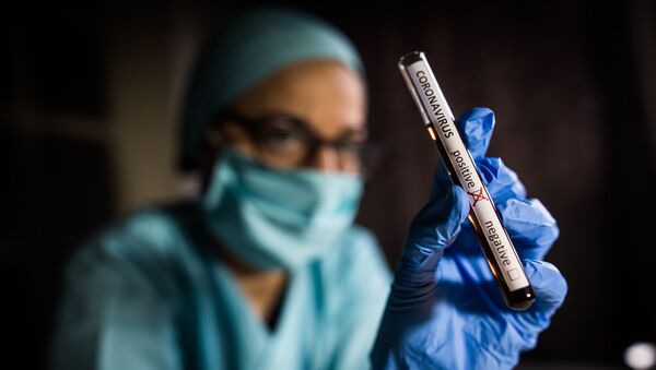 Рука врача, держащего пробирку с положительными пробами на наличие коронавируса (COVID-19) - Sputnik Lietuva