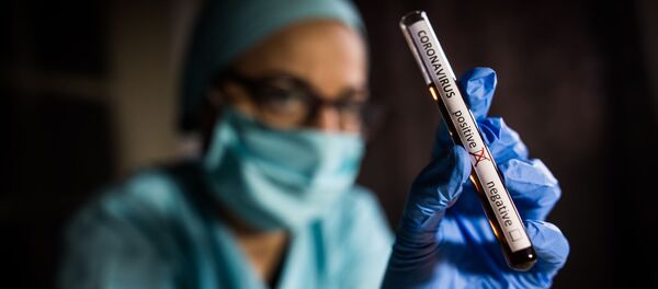 Рука врача, держащего пробирку с положительными пробами на наличие коронавируса (COVID-19) - Sputnik Литва