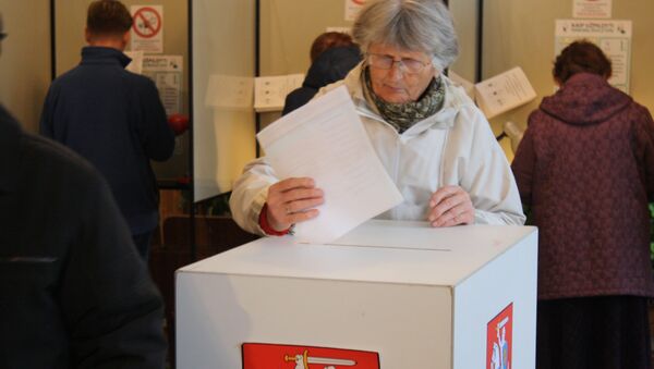 Избирательница опускает бюллетень в урну - Sputnik Литва