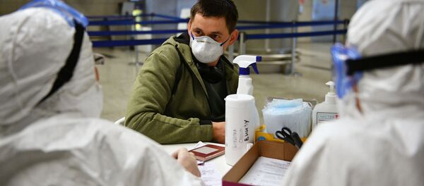 Медицинские работники во время проверки состояния пассажира в аэропорту Внуково - Sputnik Литва