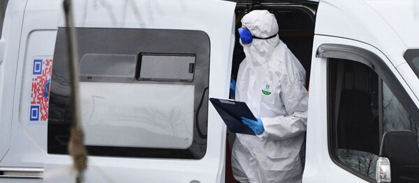Медик в машине скорой помощи у карантинного центра по коронавирусу в Коммунарке Медик в машине скорой помощи у карантинного центра по коронавирусу в Коммунарке - Sputnik Литва