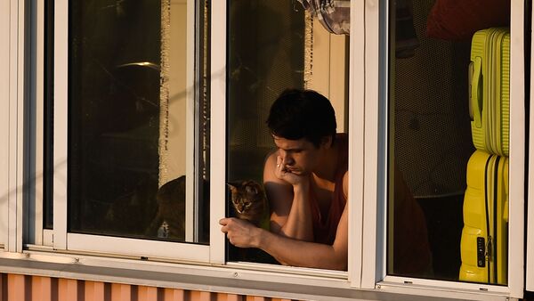 Молодой человек с кошкой на балконе многоквартирного дома в Москве - Sputnik Lietuva