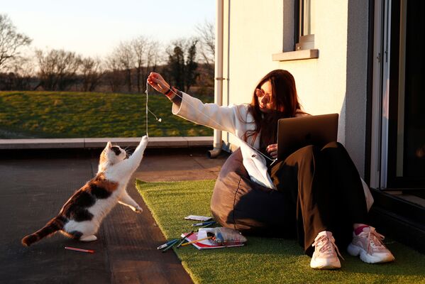 Девушка играет с кошкой на пороге своего дома в бельгийской деревне - Sputnik Lietuva