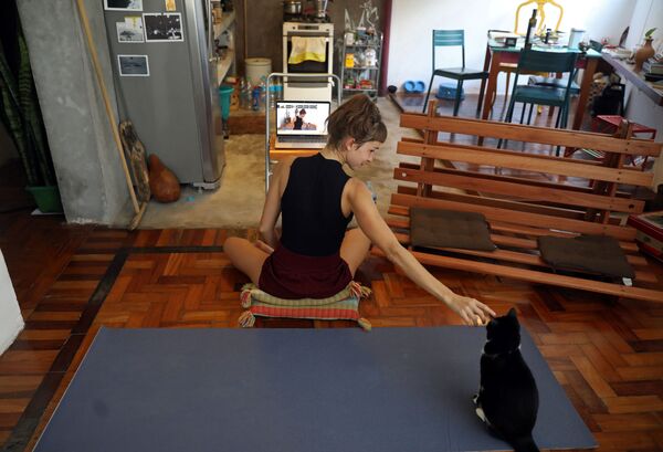 Инструктор по йоге со своей кошкой во время онлайн-урока у себя дома в Рио-де-Жанейро, Бразилия - Sputnik Lietuva