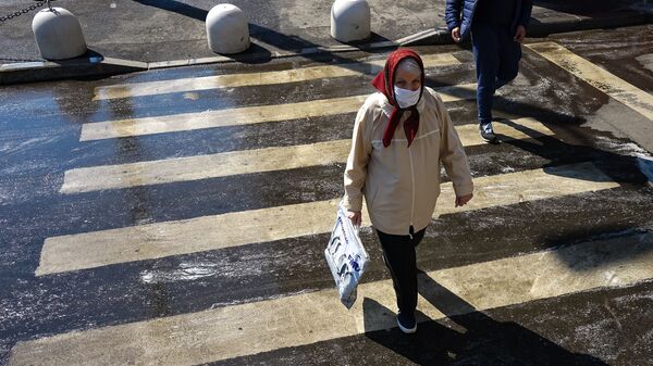 Pagyvenusi moteris su kauke pėsčiųjų perėjoje - Sputnik Lietuva