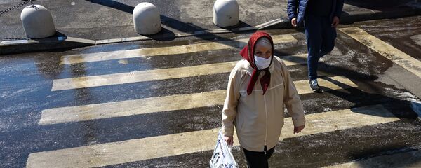 Пожилая женщина в маске на пешеходном переходе Пожилая женщина в маске на пешеходном переходе - Sputnik Lietuva