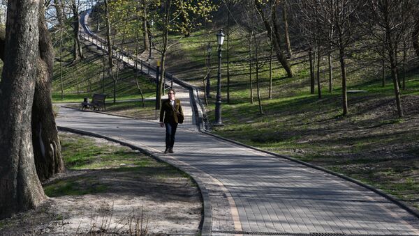 Прохожий во Владимирском парке в Киеве во время карантина - Sputnik Литва