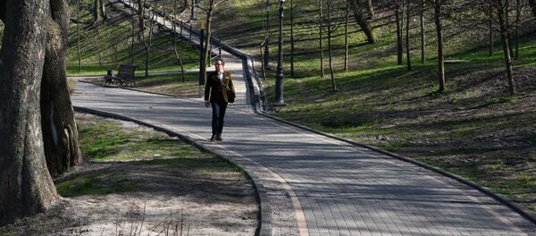 Прохожий во Владимирском парке в Киеве во время карантина - Sputnik Литва