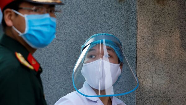 Медицинский работник в защитной маске рядом с солдатом, возле больницы во время вспышки коронавирусна в Ханое, Вьетнам - Sputnik Lietuva