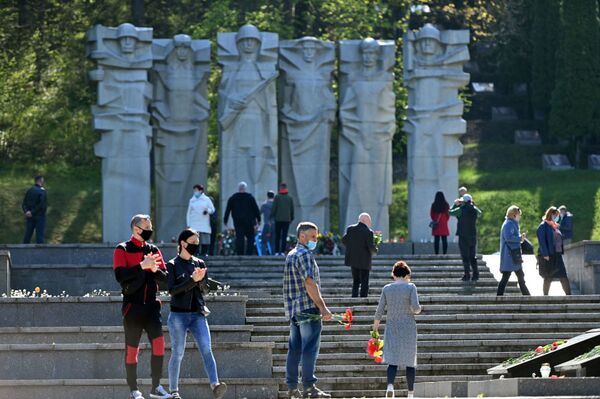 В Литве, несмотря на карантин, жители столицы отправились к мемориалам павших советских воинов, чтобы возложить цветы в честь их подвига (9 мая 2020). Вильнюс - Sputnik Lietuva