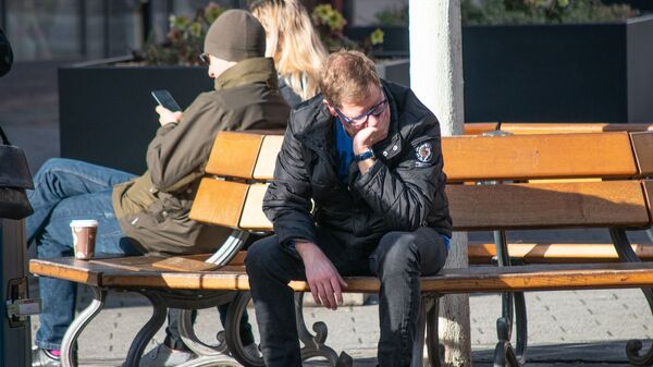 Молодой человек сидит на скамейке - Sputnik Lietuva