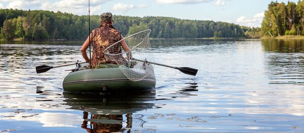 Рыбак на резиновой лодке, архивное фото - Sputnik Литва
