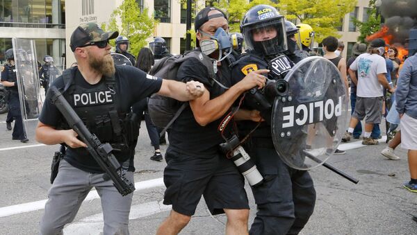 Полицейский толкает фотографа во время протестов в США  - Sputnik Lietuva
