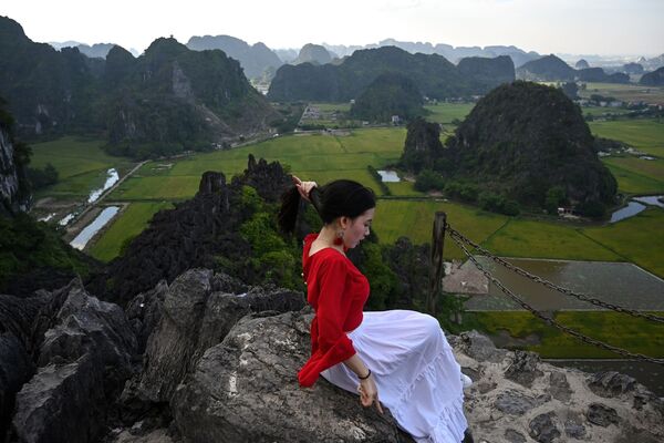 Девушка на скале во время фотографирования на смотровой площадке пещеры Муа во Вьетнаме  - Sputnik Литва