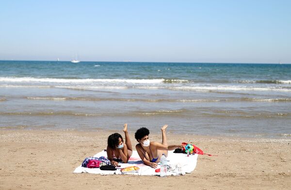 Девушки в защитных медицинских масках на пляже Malvarrosa в Валенсии, Испания - Sputnik Lietuva