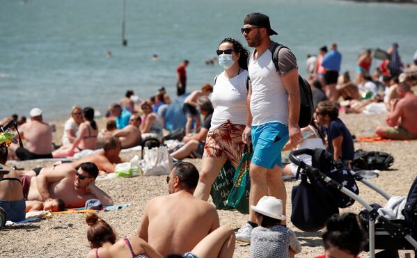 Пара в защитных масках на пляже в Саутенд-он-Си, Великобритания  - Sputnik Lietuva