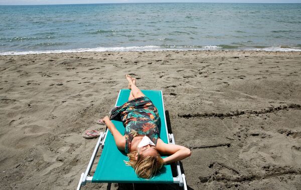 Девушка загорает на пляже в Италии - Sputnik Lietuva