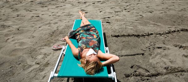 Девушка загорает на пляже в Италии Девушка загорает на пляже в Италии - Sputnik Lietuva