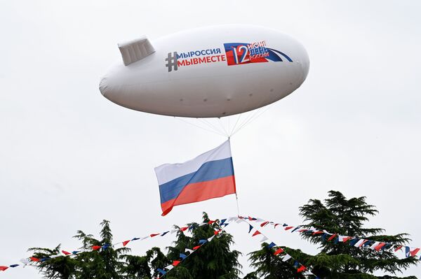 Аэростат, украшенный флажковой гирляндой цвета российского триколора, во время празднования Дня России в Сочи - Sputnik Литва