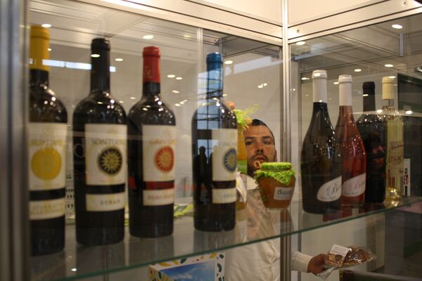 Сотрудник компании готовит к показу стенд с традиционными итальянскими винами. - Sputnik Литва