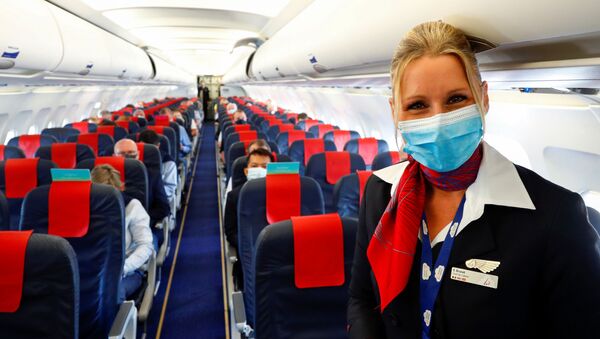 Стюардесса в медицинской маске в салоне самолета в международном аэропорту Брюсселя - Sputnik Литва