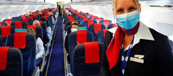 Стюардесса в медицинской маске в салоне самолета в международном аэропорту Брюсселя - Sputnik Литва