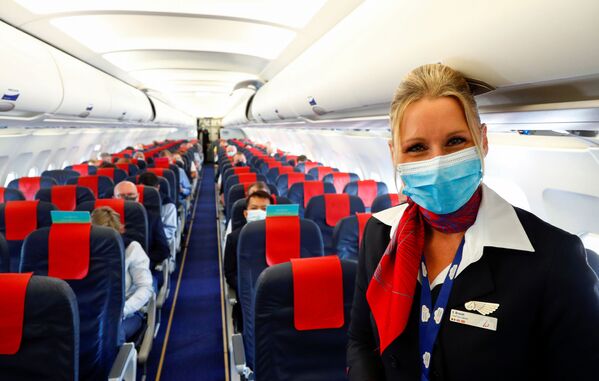 Стюардесса в медицинской маске в салоне самолета в международном аэропорту Брюсселя - Sputnik Lietuva
