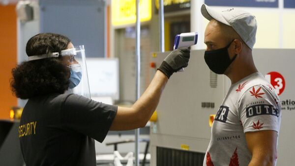 Пассажир в защитной маске проходит температурный контроль в международном аэропорту Борисполь в Киеве - Sputnik Lietuva